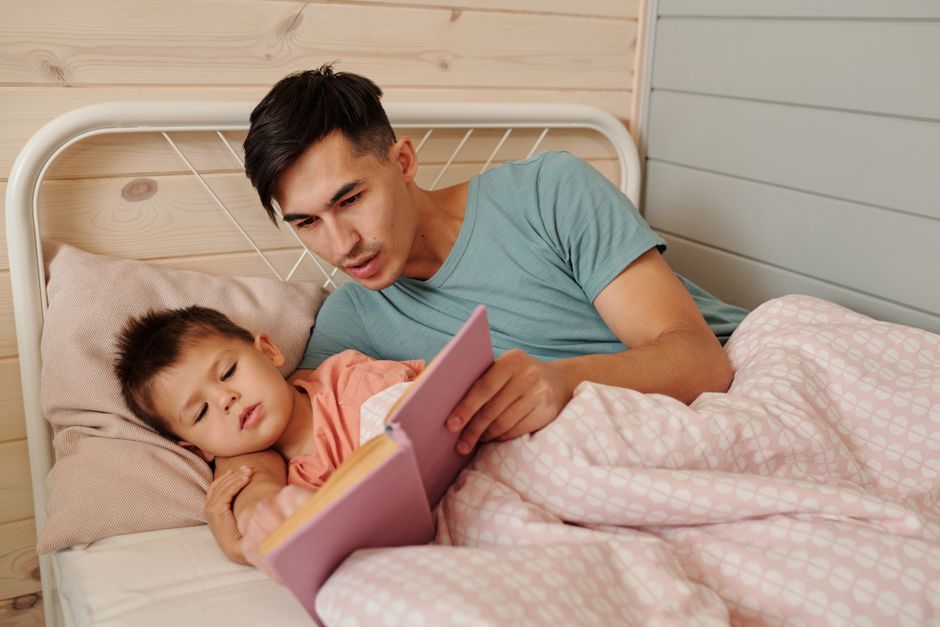 Cozy family moment as father reads a bedtime story to his son at home.